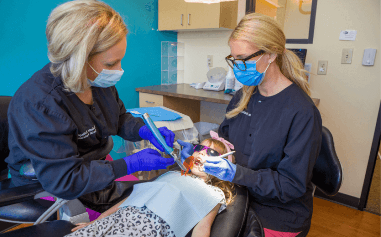 Dentists treating comfortable patient | Carpenter Pediatric Dentistry | Aurora, CO
